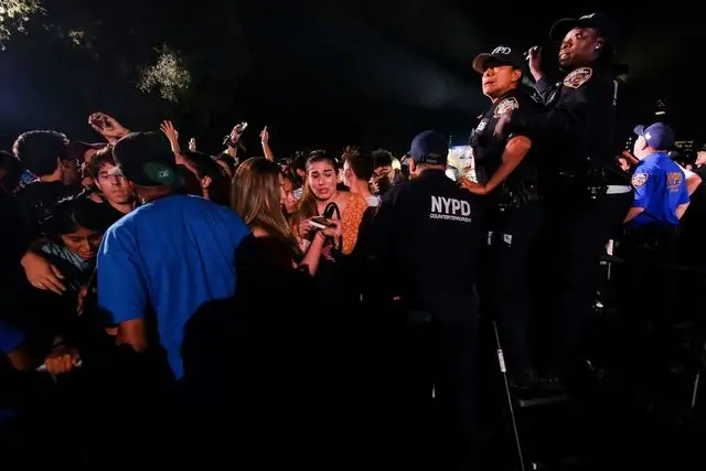 Concert goers surge forward after a gunshot false alarm at the Global Citizens Festival
